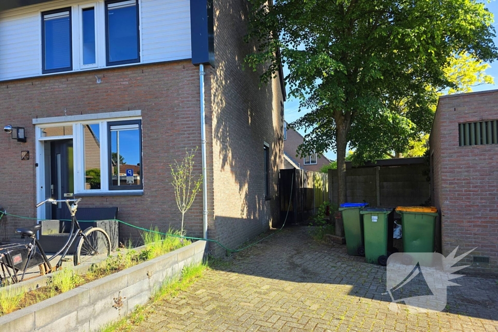Schutting naast woning in brand