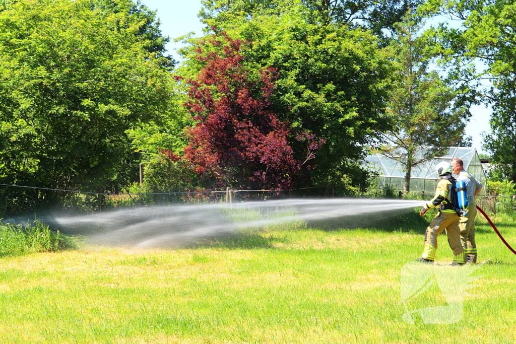 Brand in bosschage slaat over op gebouw