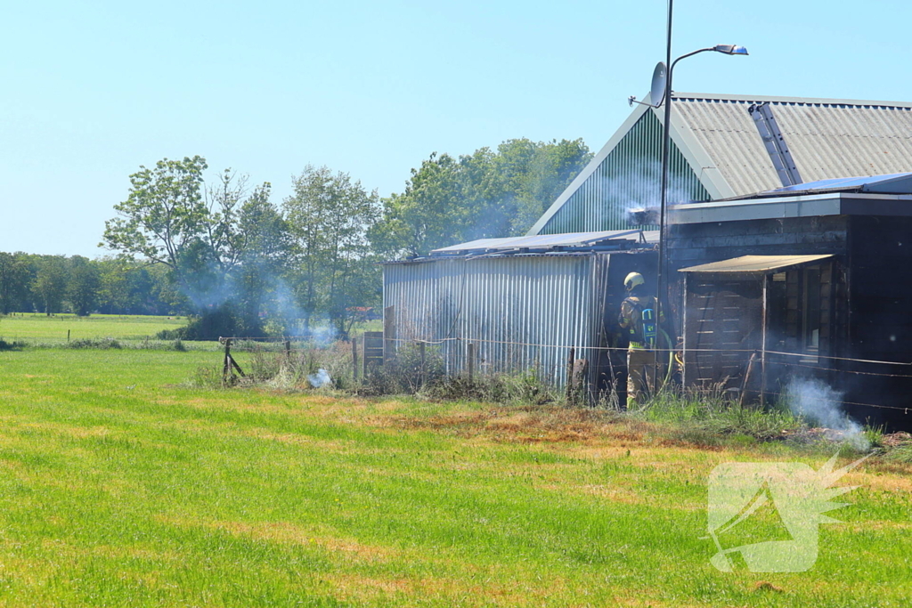 Brand in bosschage slaat over op gebouw