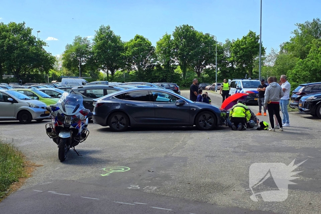Scooterrijder botst tegen Tesla op parkeerplaats