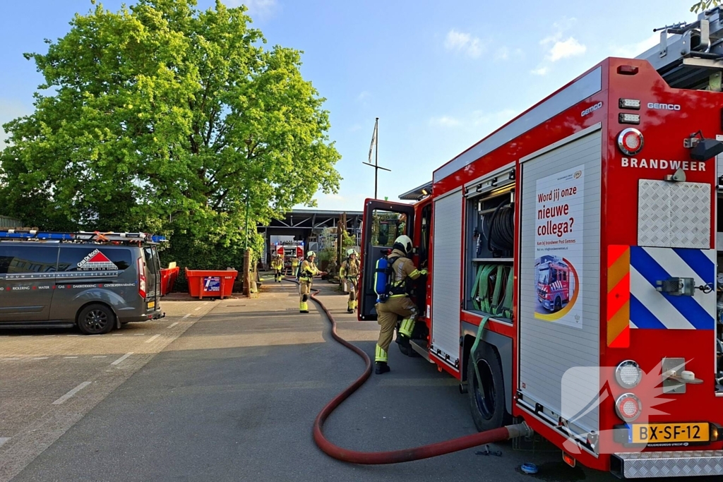 Palletopslag in brand, gebouw bedreigt