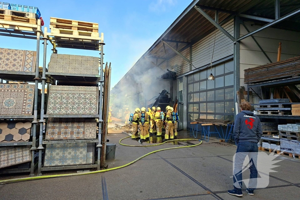 Palletopslag in brand, gebouw bedreigt