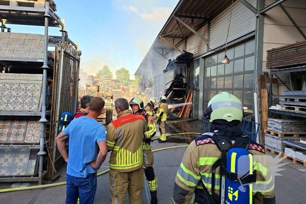 Palletopslag in brand, gebouw bedreigt