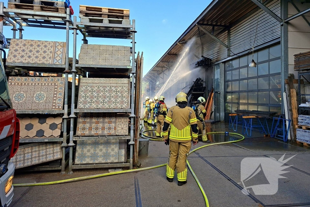 Palletopslag in brand, gebouw bedreigt