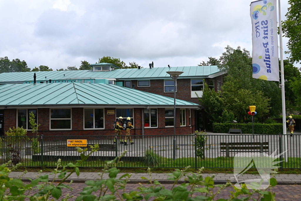 Rook uit dak van schoolgebouw