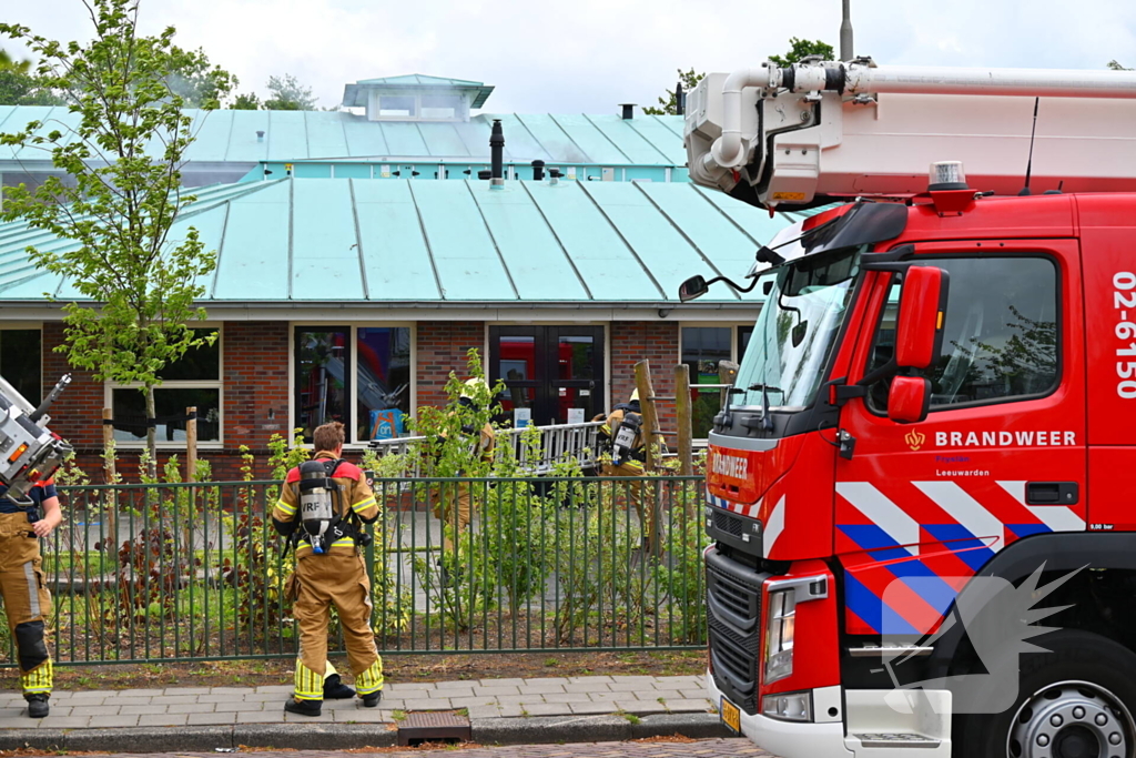 Rook uit dak van schoolgebouw