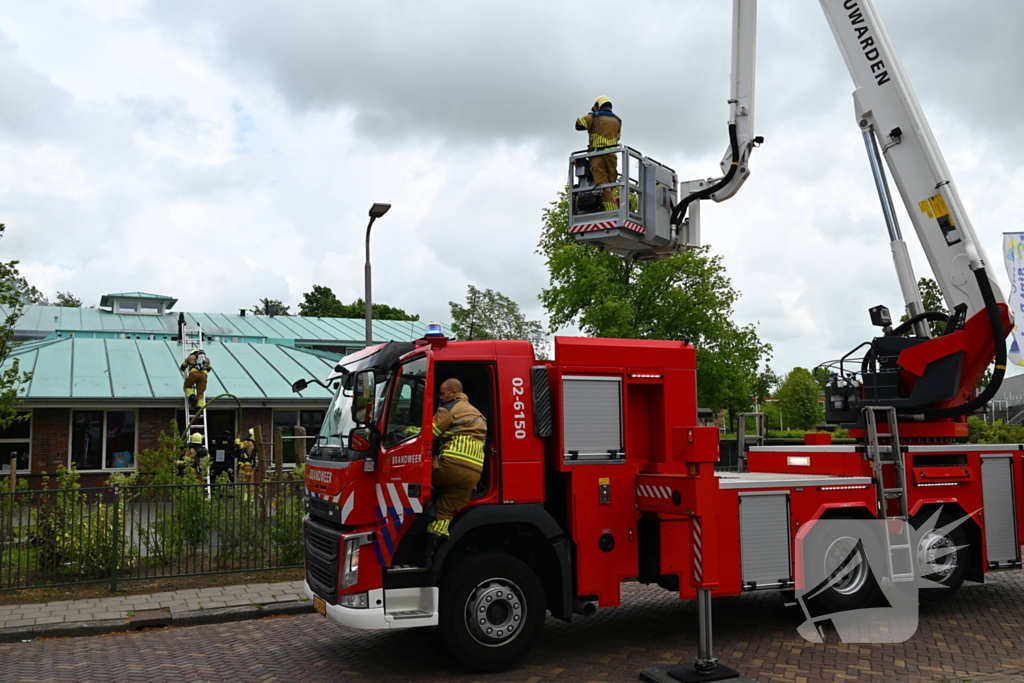 Rook uit dak van schoolgebouw
