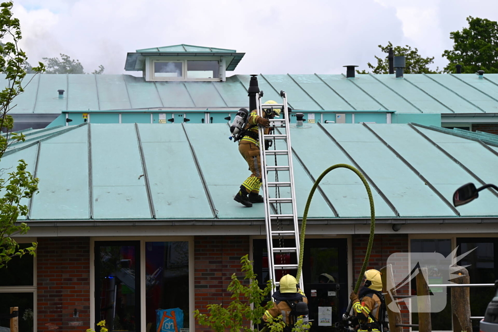 Rook uit dak van schoolgebouw