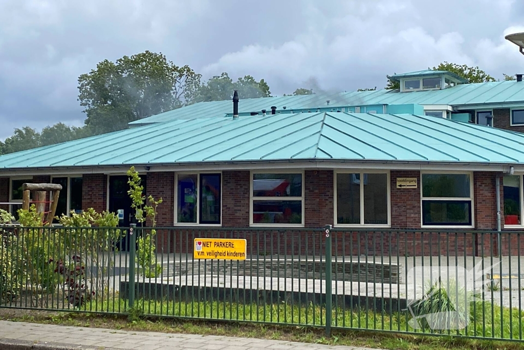 Rook uit dak van schoolgebouw