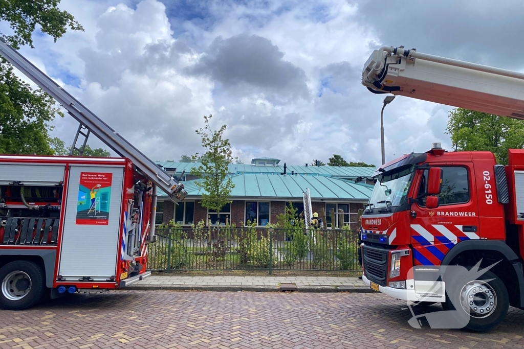 Rook uit dak van schoolgebouw