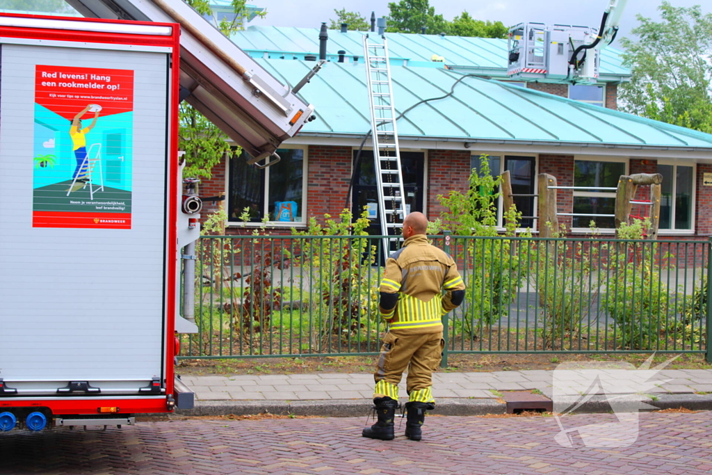 Rook uit dak van schoolgebouw