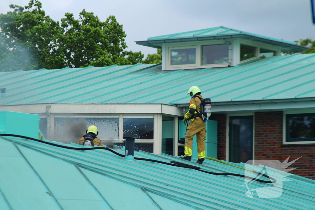 Rook uit dak van schoolgebouw