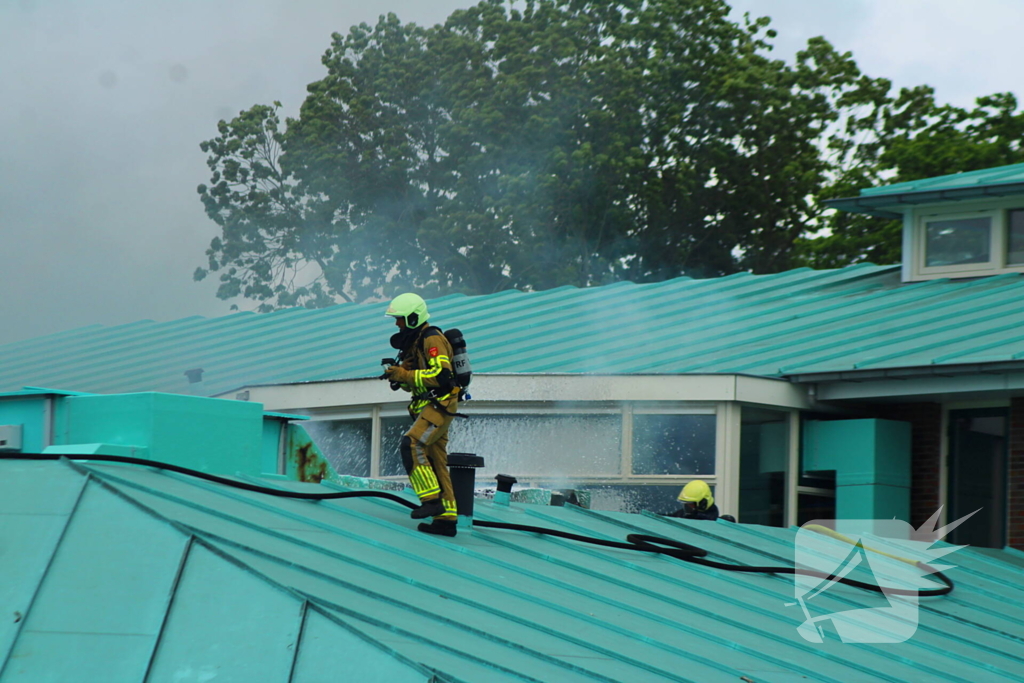 Rook uit dak van schoolgebouw