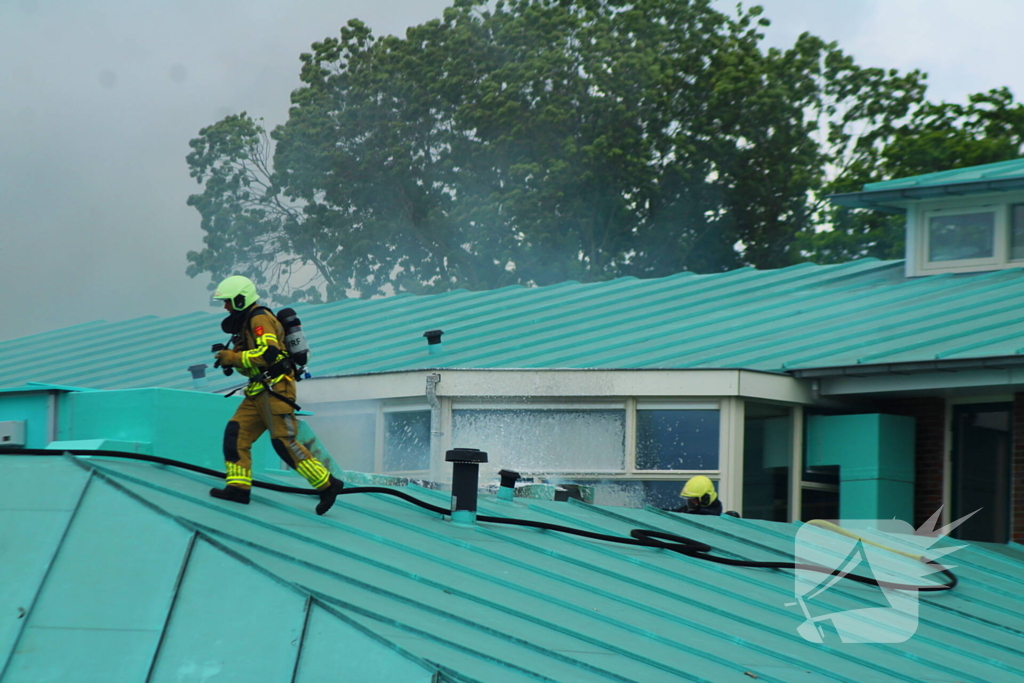 Rook uit dak van schoolgebouw