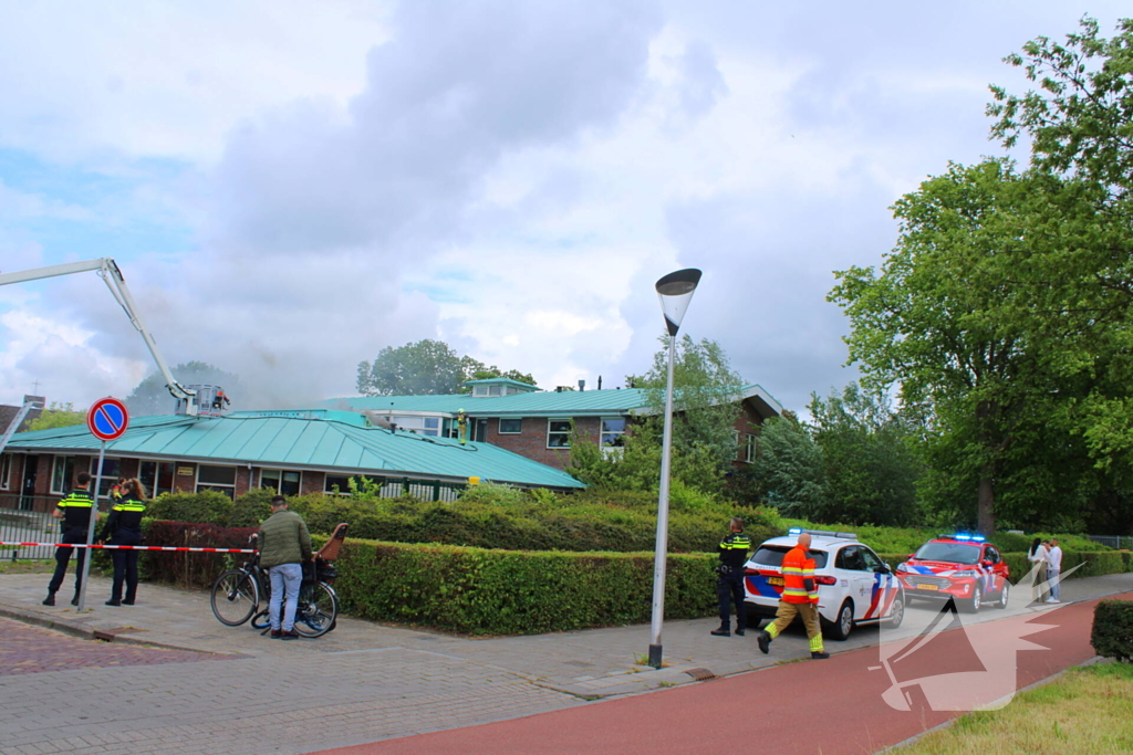 Rook uit dak van schoolgebouw