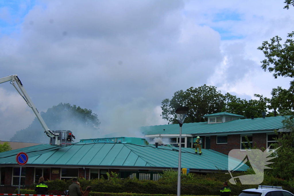 Rook uit dak van schoolgebouw