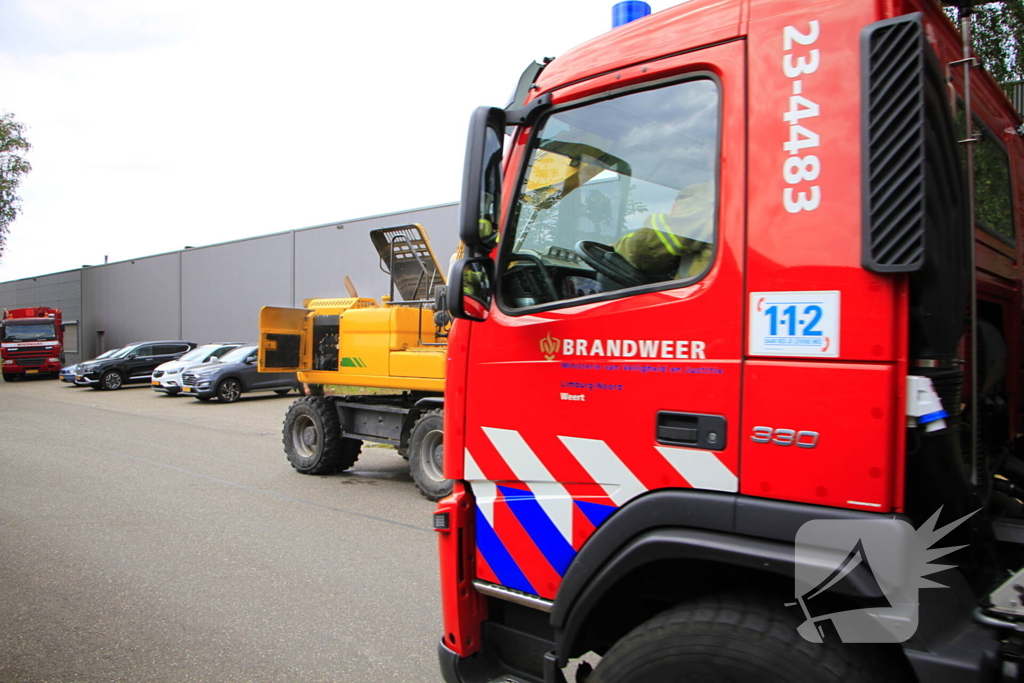 Grijpmachine vat vlam in loods