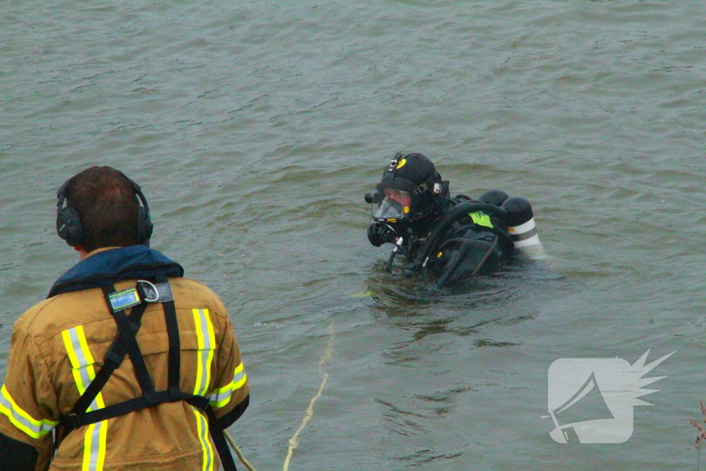 Duikers zoeken naar auto in rivier