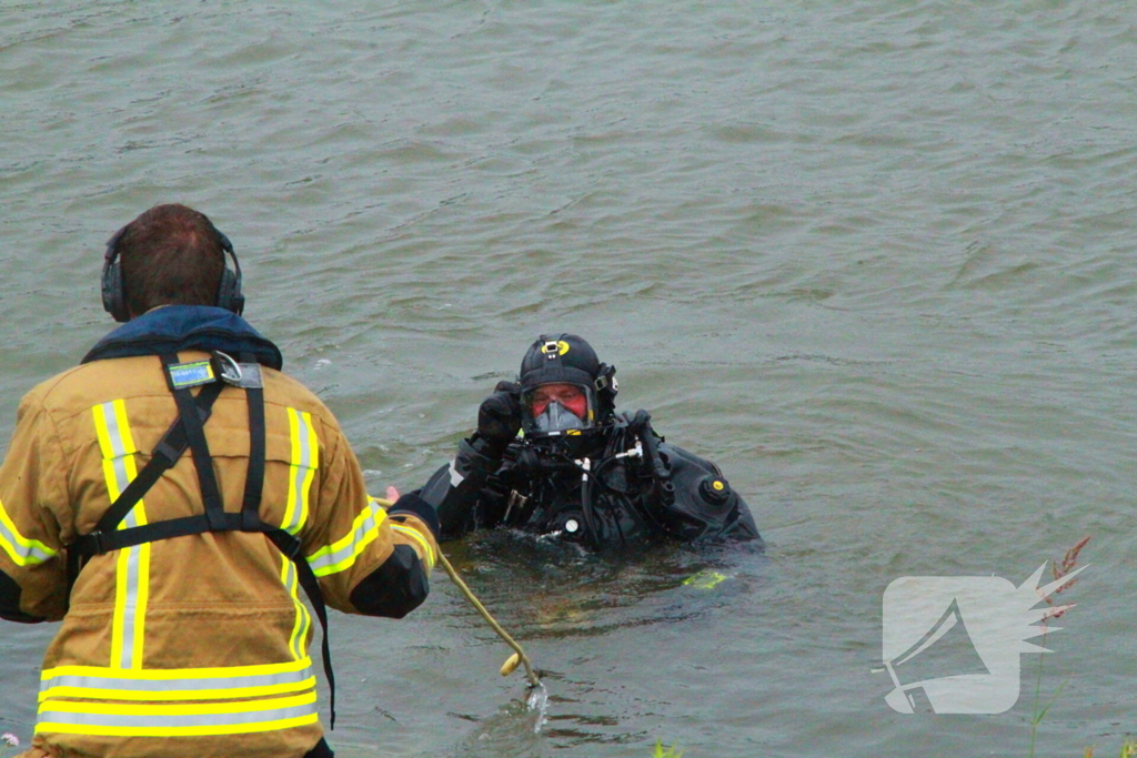 Duikers zoeken naar auto in rivier