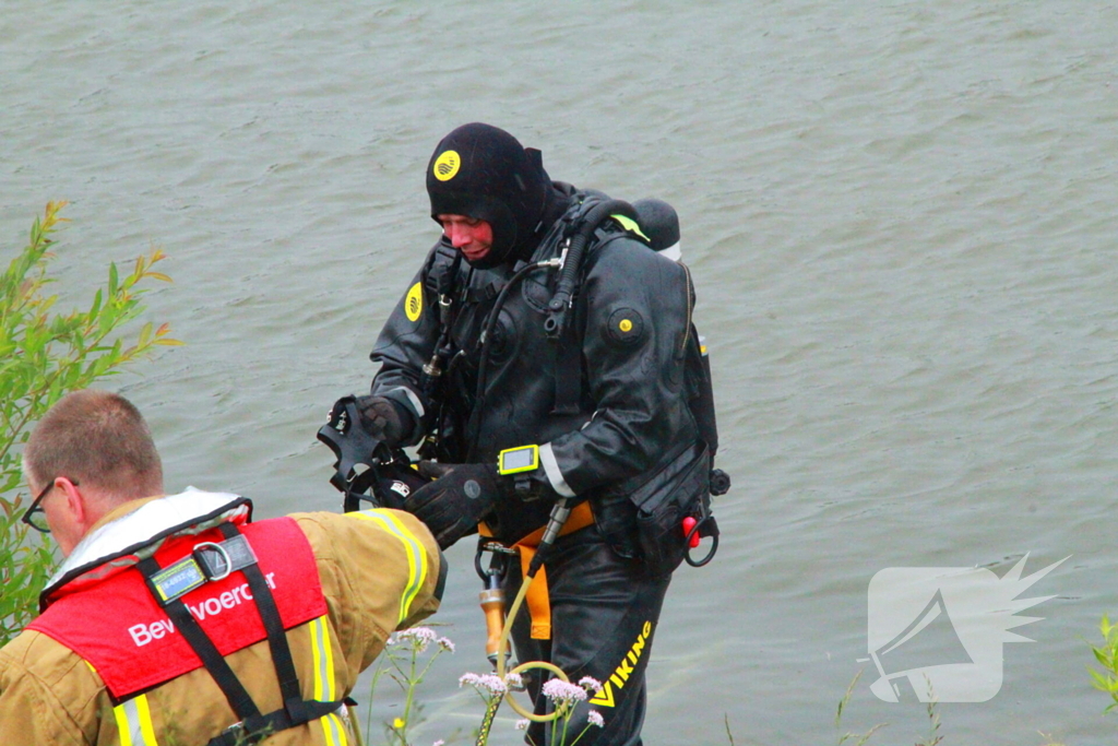 Duikers zoeken naar auto in rivier