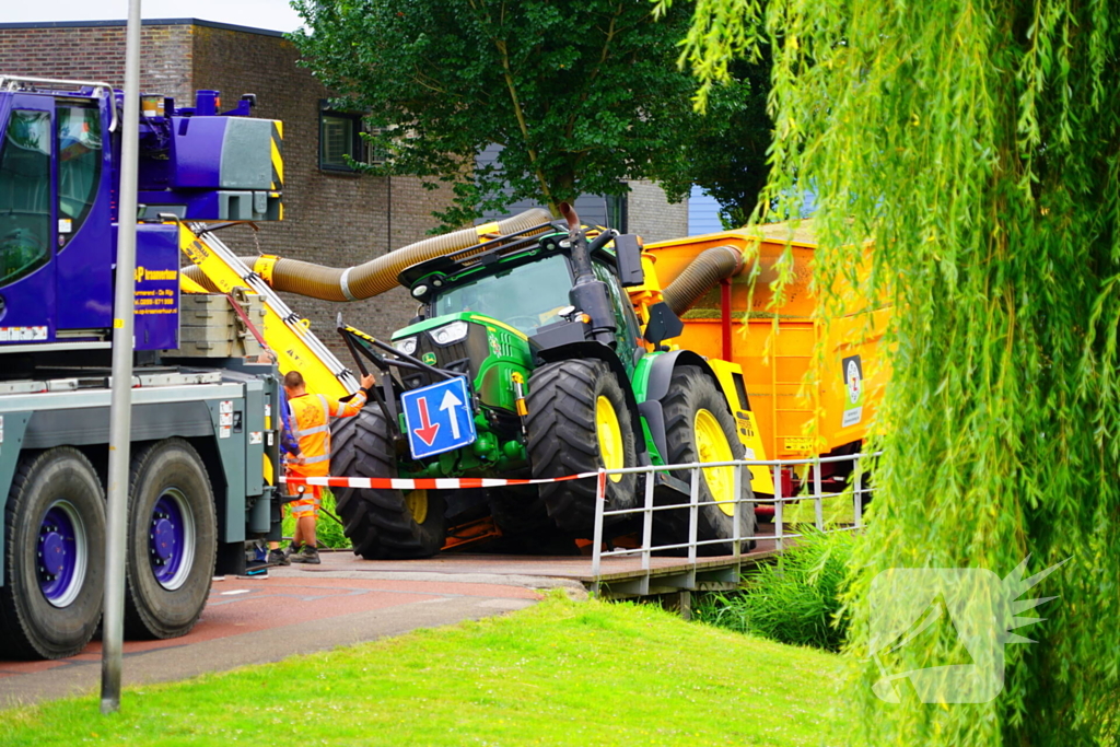 Tractor zakt door brug tijdens werk