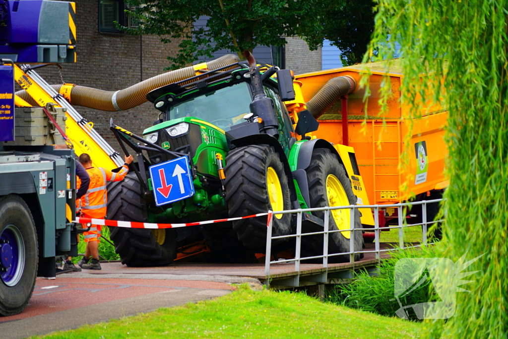 Tractor zakt door brug tijdens werk