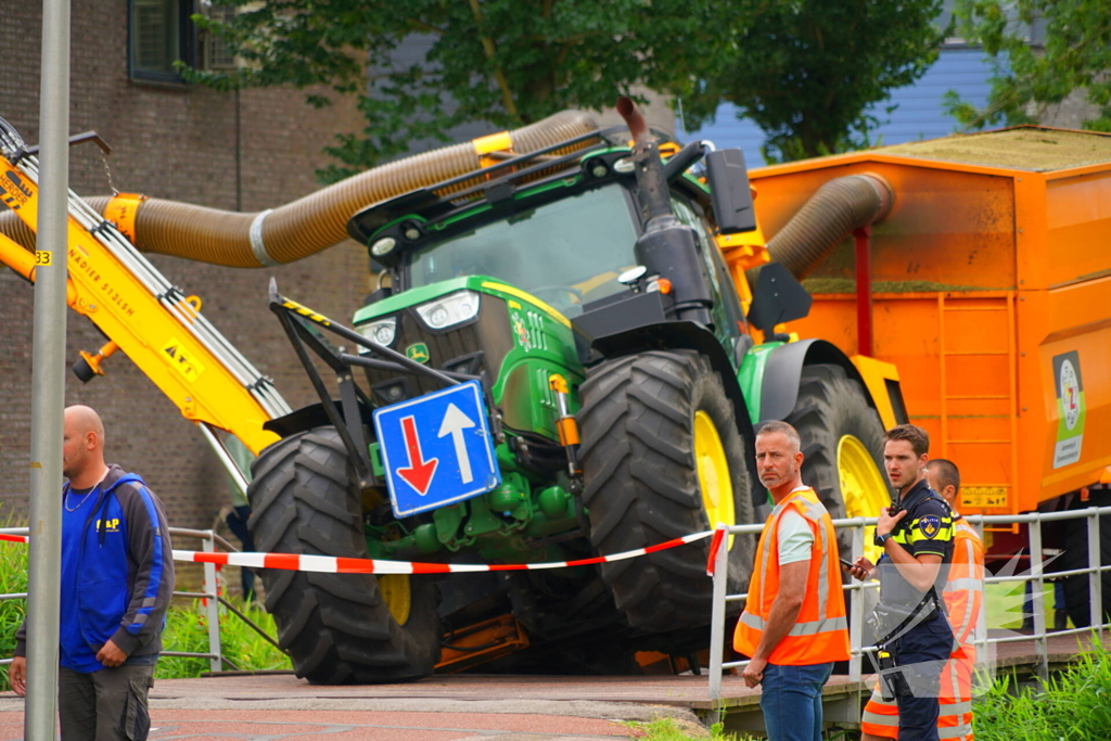 Tractor zakt door brug tijdens werk