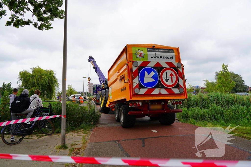 Tractor zakt door brug tijdens werk