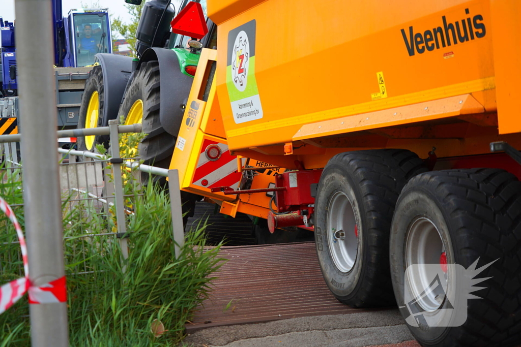 Tractor zakt door brug tijdens werk