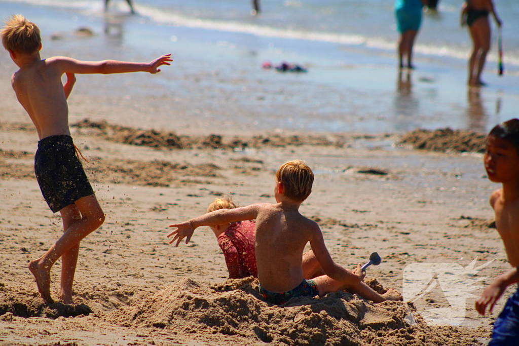 Mens en dier zoeken verkoeling aan het strand