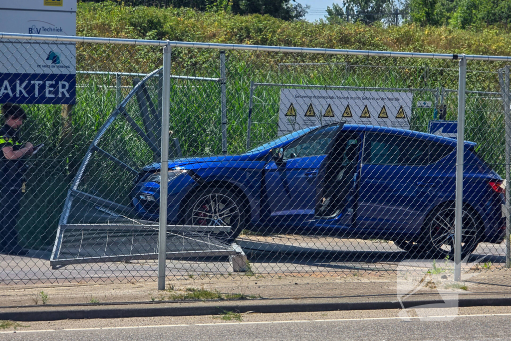 Automobilist ramt hekwerk bij bouwplaats