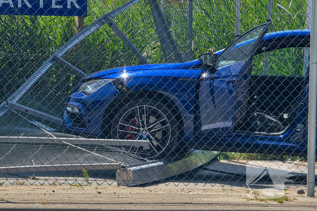 Automobilist ramt hekwerk bij bouwplaats