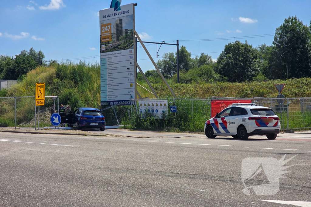 Automobilist ramt hekwerk bij bouwplaats
