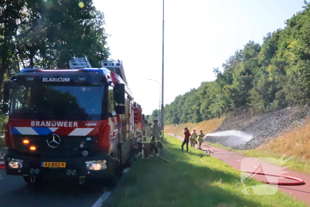 Berm vliegt in brand, brandweer voorkomt erger
