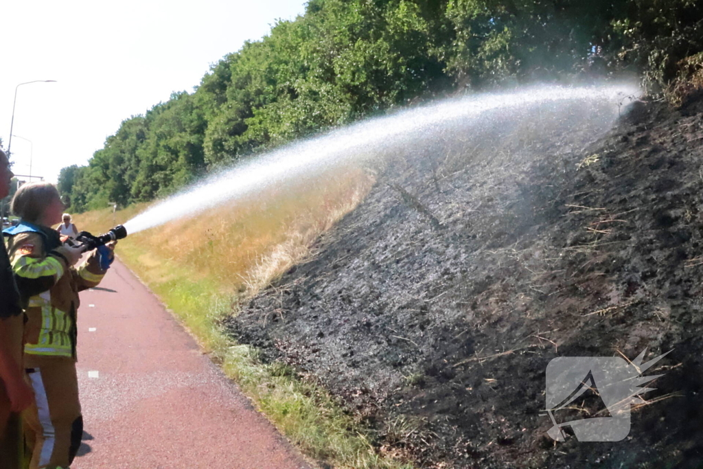 Berm vliegt in brand, brandweer voorkomt erger