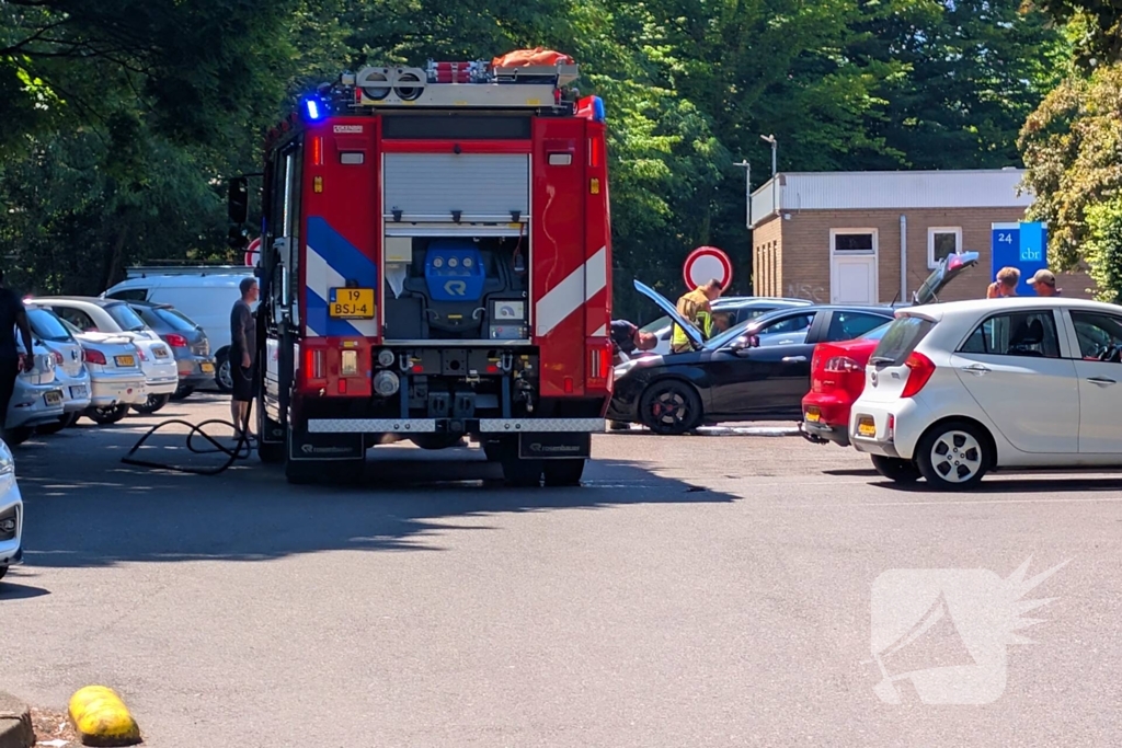 Brandweer blust auto op parkeerterrein