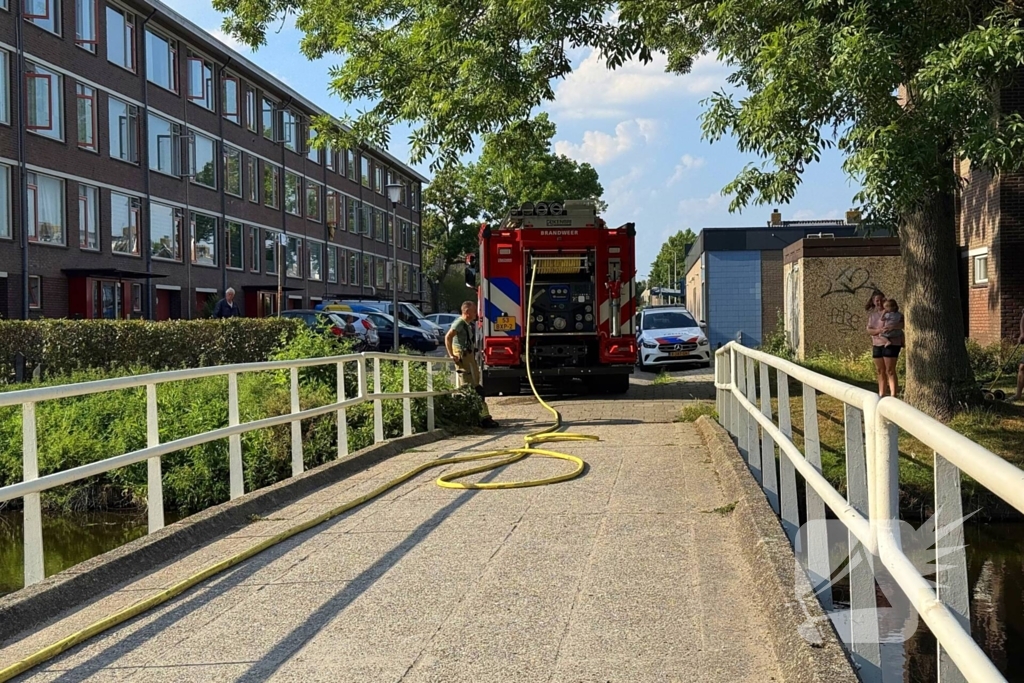 Omstander helpt brandweer met blussen van brand in bosschage
