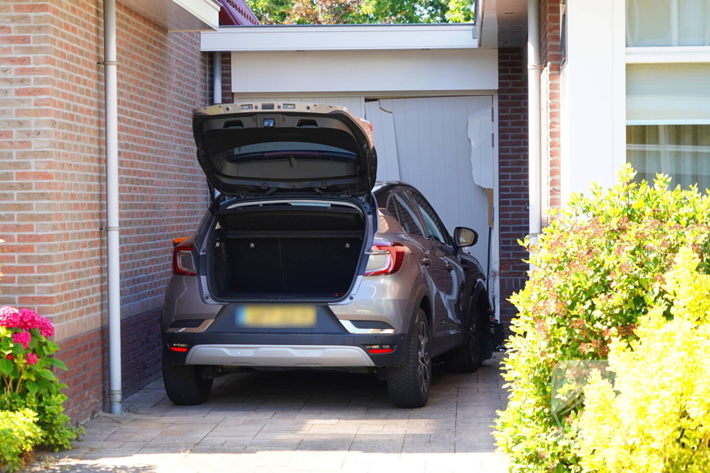 Auto rijdt garage binnen tijdens inparkeren