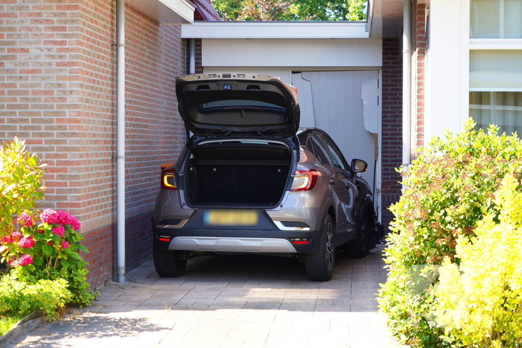 Auto rijdt garage binnen tijdens inparkeren