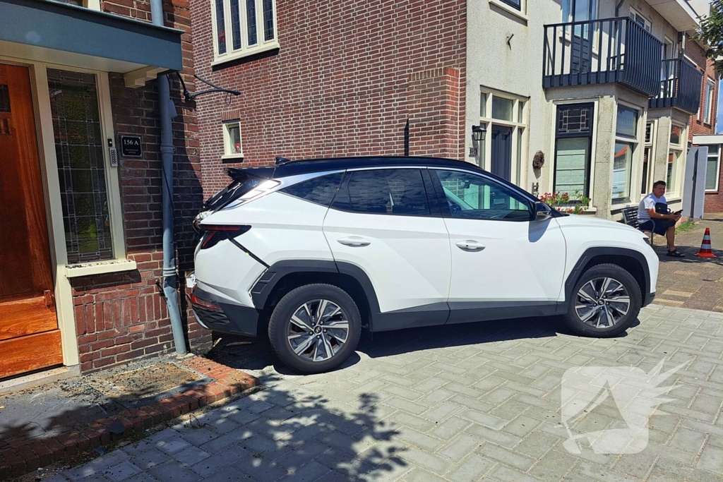 Auto rijdt achteruit tegen woning