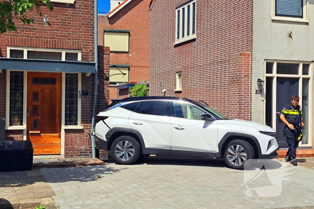 Auto rijdt achteruit tegen woning