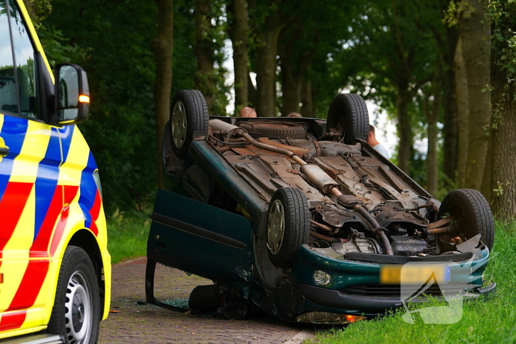 Auto over de kop na botsing