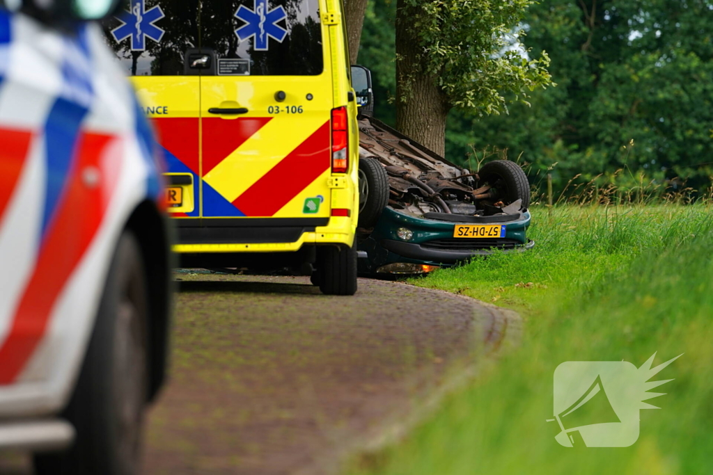 Auto over de kop na botsing