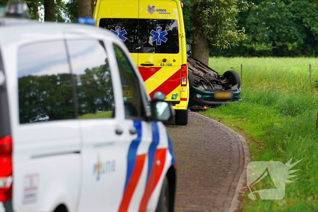 Auto over de kop na botsing