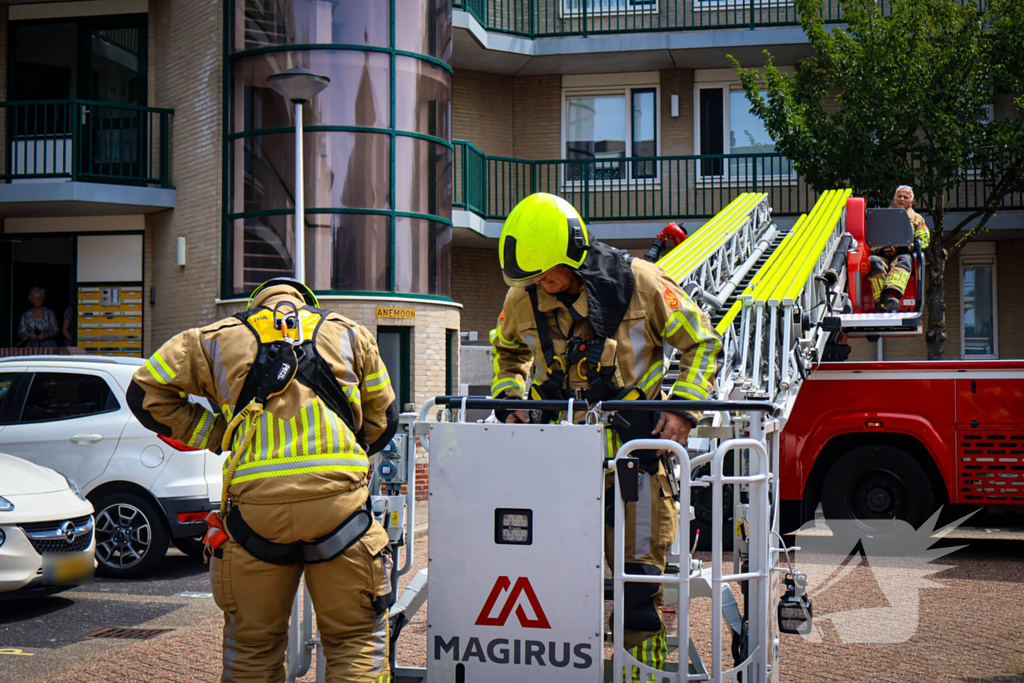 Los gewaaide parasol belandt op dak appartementencomplex