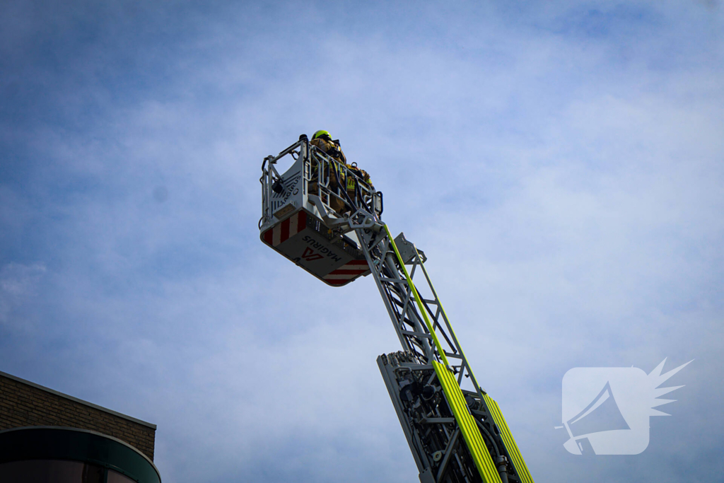 Los gewaaide parasol belandt op dak appartementencomplex