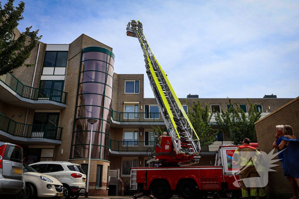 Los gewaaide parasol belandt op dak appartementencomplex