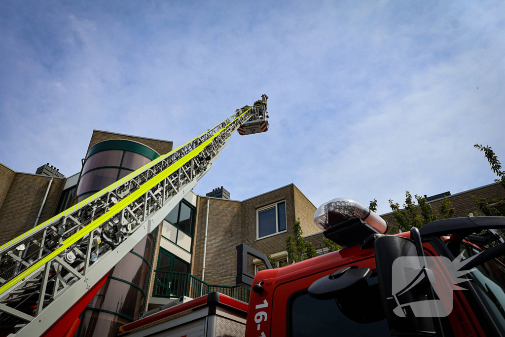 Los gewaaide parasol belandt op dak appartementencomplex