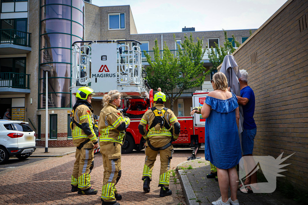 Los gewaaide parasol belandt op dak appartementencomplex