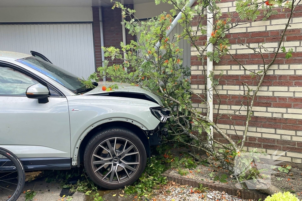 Voertuig ramt boom en huis